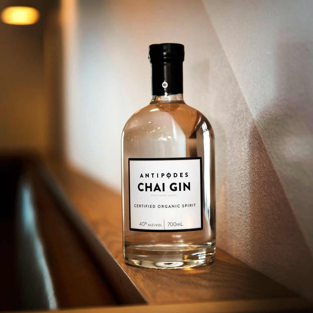 Bottle of Antipodes Chai Gin on a wooden surface with soft lighting