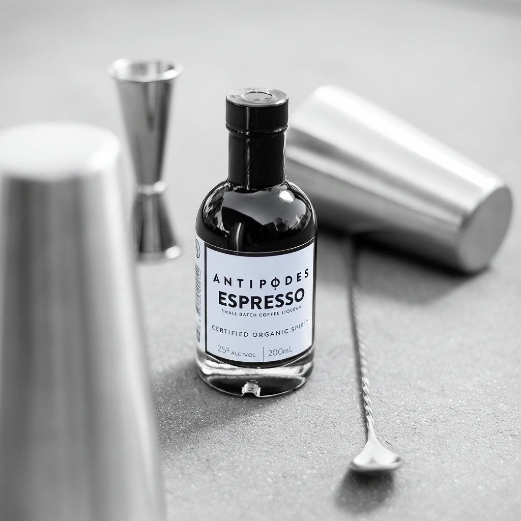 Bottle of Antipodes Espresso on a gray surface with bar tools in the background