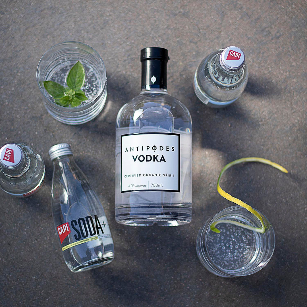 Bottle of Antipodes Vodka with garnishes on a gray surface