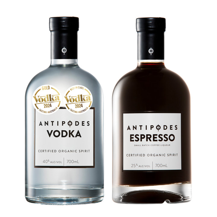 Two 700mL bottles of Antipödes Vodka from their Gold Vodka 2024 collection, shown side-by-side on a white background. The left bottle is a clear glass bottle of Vodka, and the right bottle is a dark brown glass bottle of Espresso coffee liqueur.